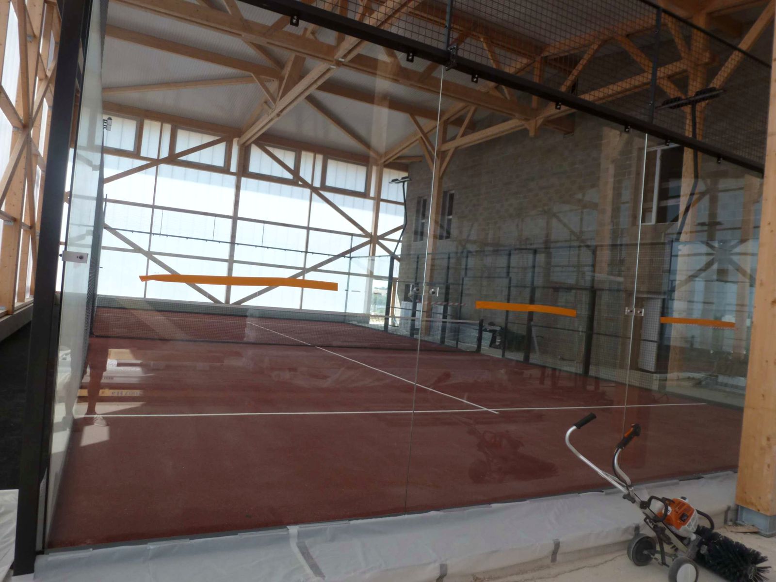 Piste à gazon terre battue sous charpente bois, chantier AGEPADEL à Padel Millenium
